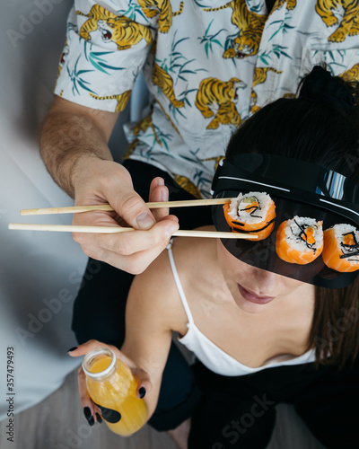 Rolls and sushi on a white plate. Hand with sushi sticks. 