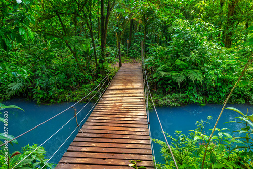 Rio Celeste with turquoise, blue water and small wooden bridge across the river Tenorio national park Costa Rica. Central America.