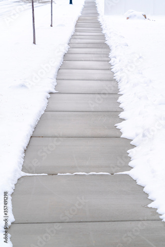 Narrow walkway on ground covered with fresh white snow in winter season © Jason