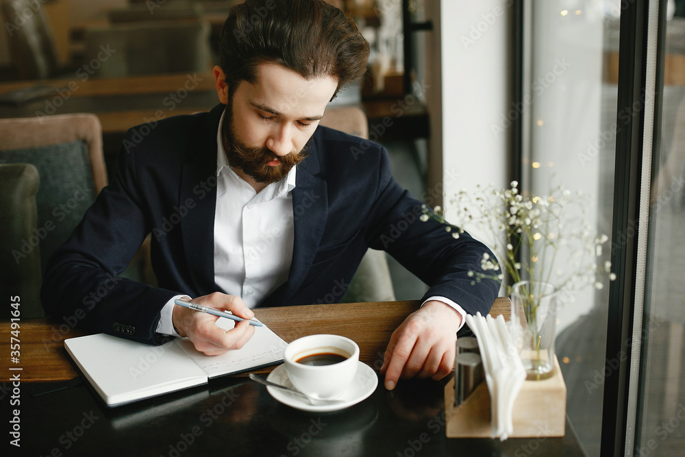 Handsome man in a black suit. Businessman working in a office Handsome man in a black suit. Businessman working in a office