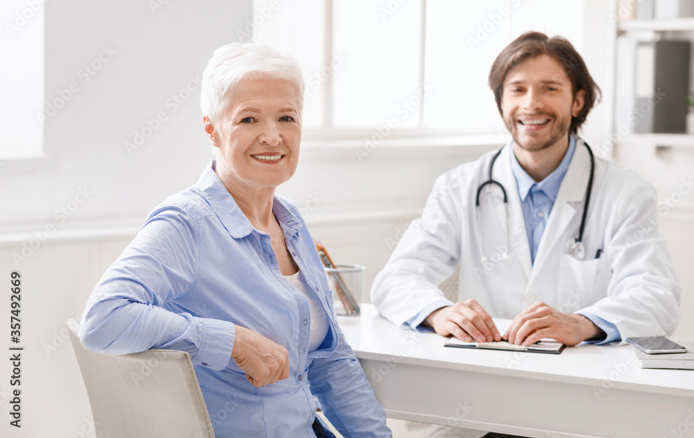 Geriatrician and senior female patient smiling at camera Geriatrician and senior female patient smiling at camera