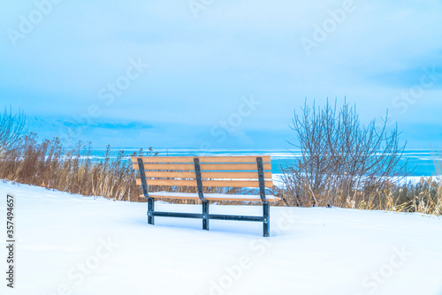 Back view of outdoor bench overlooking Utah Lake and cloudy sky over the horizon
