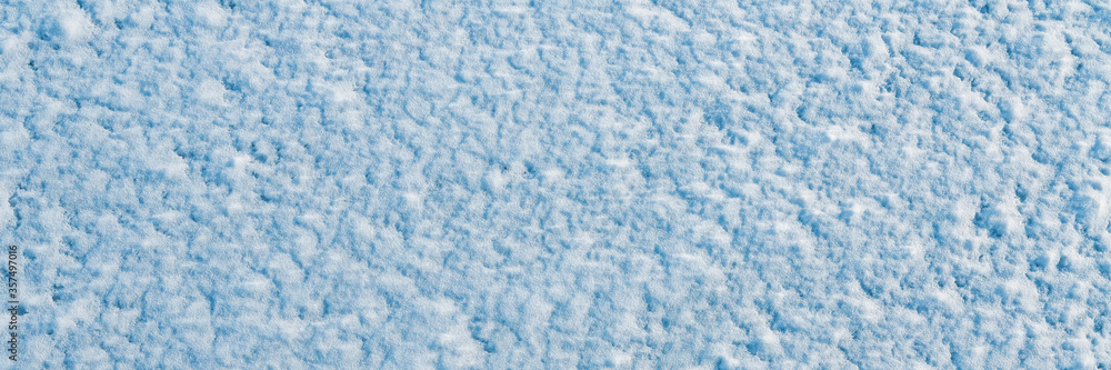 Natural snow texture. The surface of clean fresh snow. Snowy ground. Winter background with snow patterns. Perfect for Christmas and New Year design. Closeup top view.