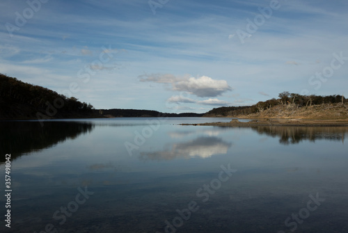 View of the pure water lake in the forest, under a beautiful sky and its reflection in the water surface.  © Gonzalo