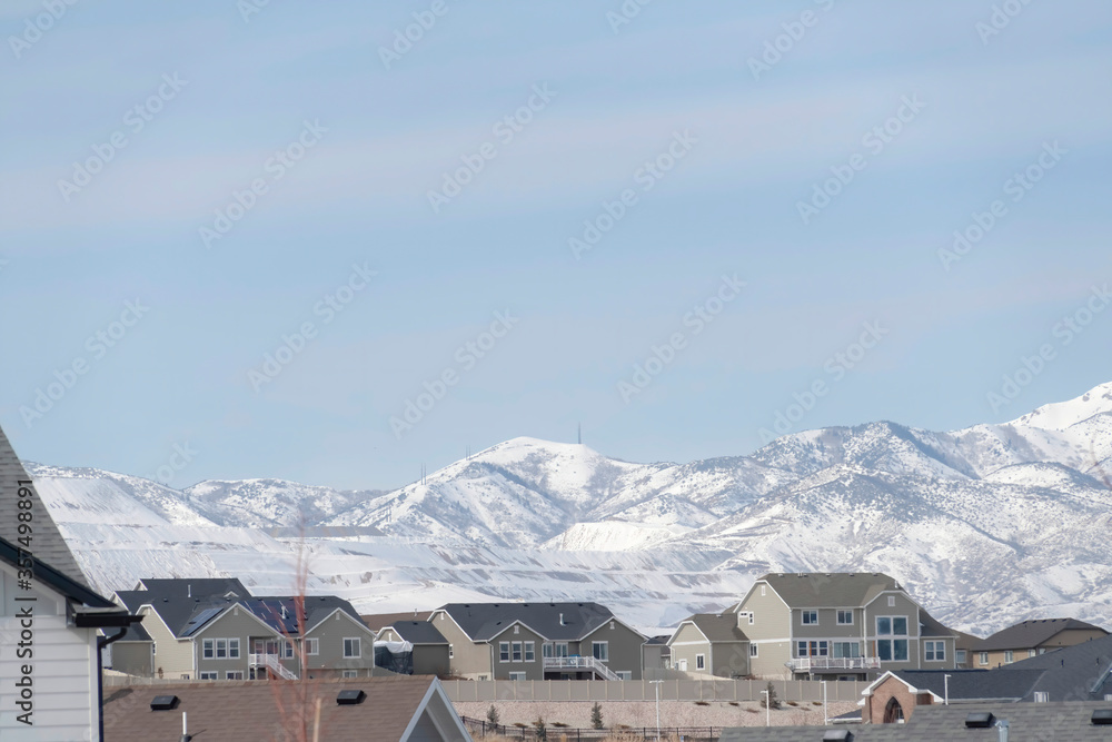 Neighborhood in South Jordan City against snowy Wasatch Mountains and cloudy sky