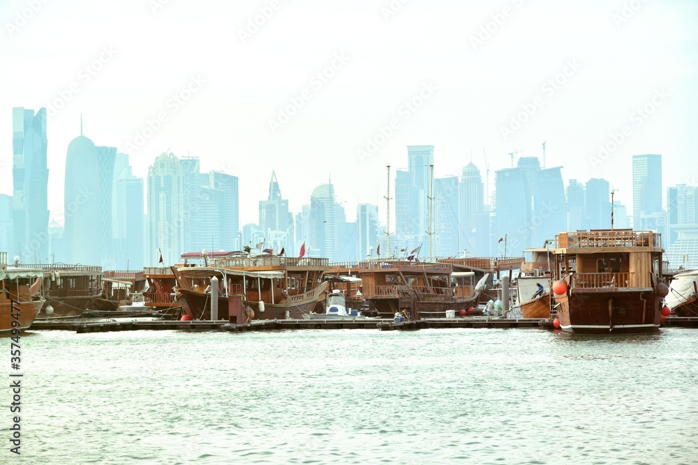 Traditional dhow boat in Doha, with buildings in the background.