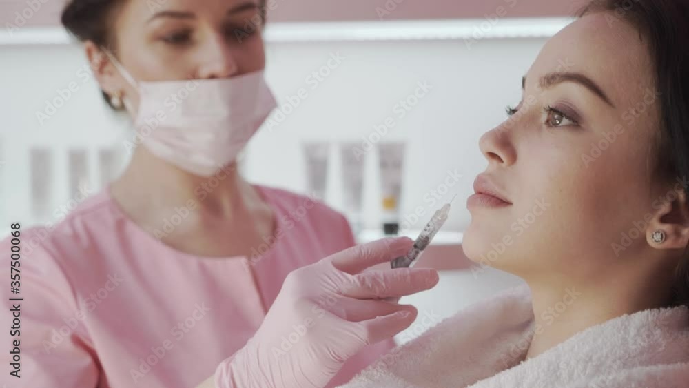 Close up Young woman having injection into her lips Close up Young woman having injection into her lips