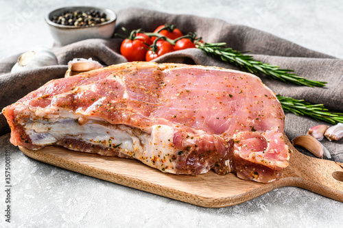 raw pork chop steak on a wooden chopping Board. Gray background. Top view