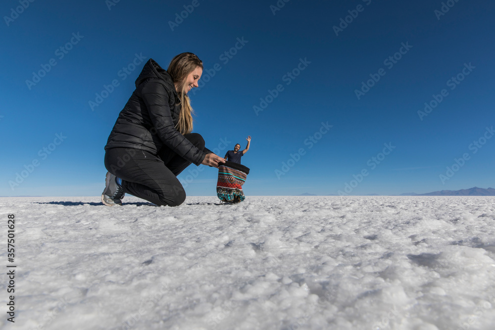 Couple playing with perspective in desert salt flats