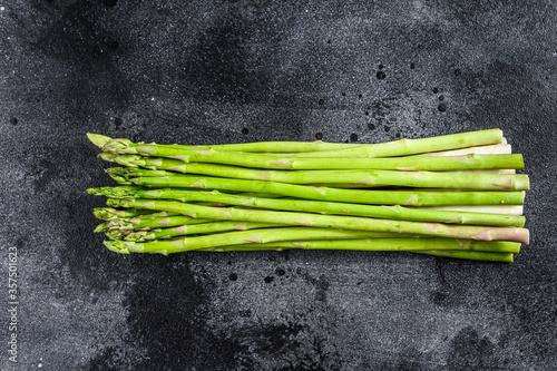 banches of fresh green asparagus. Black background. Top view