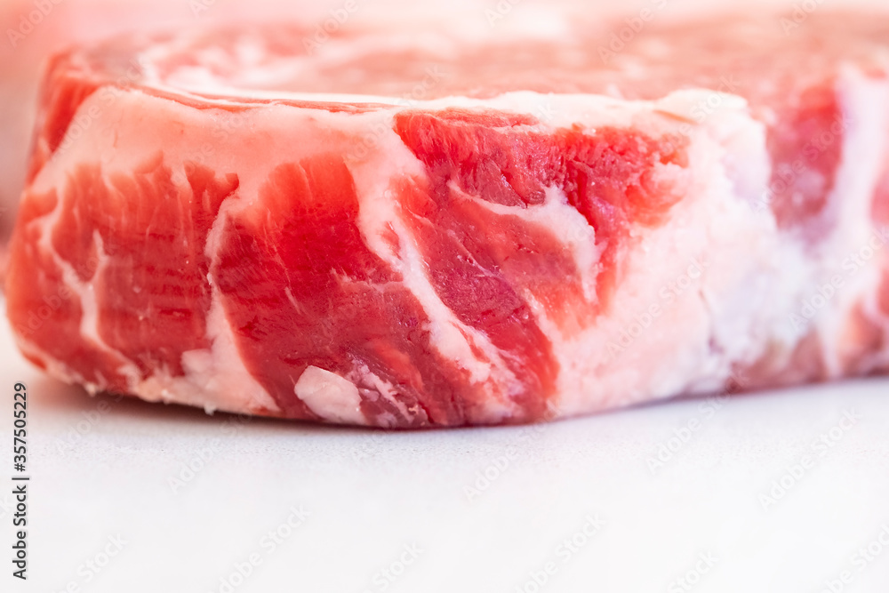 Closeup of Well Marbled Wild Boar Steak on White Backgound or Quartz Countertop Closeup of Well Marbled Wild Boar Steak on White Backgound or Quartz Countertop