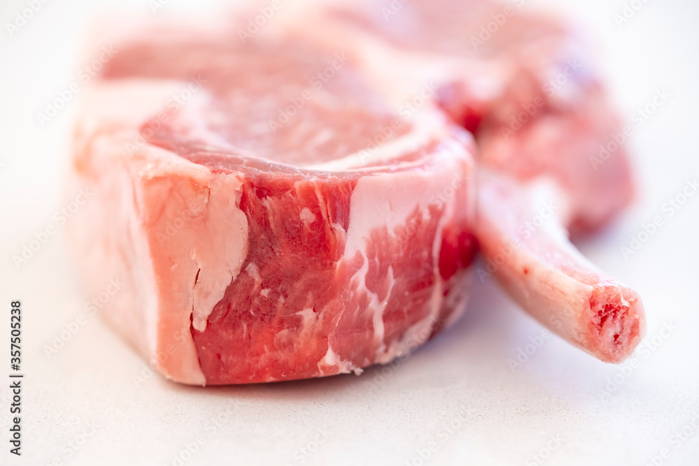 Closeup of Wild Boar Steaks on White Backgound or Quartz Countertop Closeup of Wild Boar Steaks on White Backgound or Quartz Countertop