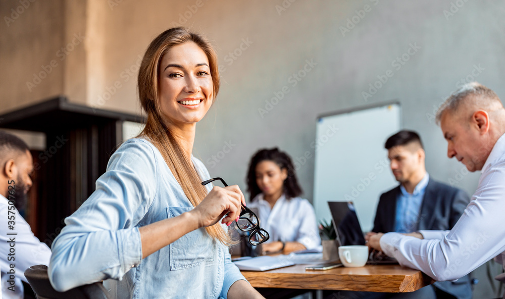 Successful Businesswoman Sitting With Employees In Modern Office Successful Businesswoman Sitting With Employees In Modern Office