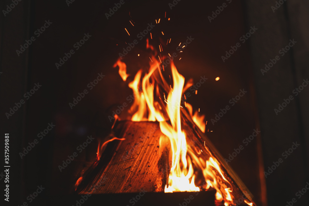 Fototapeta premium Fireplace with burning wood, closeup view. Winter vacation