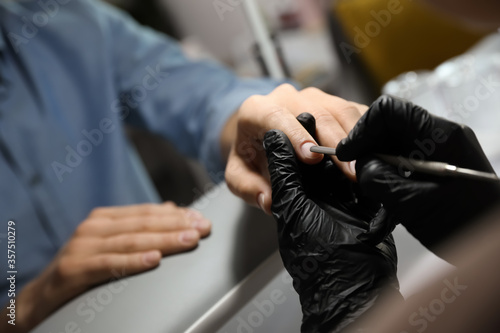 Professional manicurist working with client in beauty salon  closeup