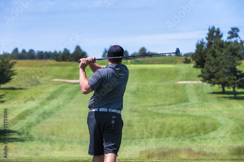 Young man hitting a driver on the tee box at a golf course