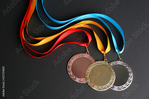 Gold, silver and bronze medals on black background, flat lay. Space for design photo