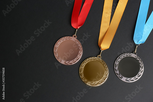 Obraz na plátně Gold, silver and bronze medals on black background, flat lay