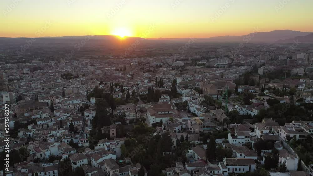 Aerial shot of houses in city against sky during sunset, drone flying forward over cityscape - Granada, Spain Aerial shot of houses in city against sky during sunset, drone flying forward over cityscape - Granada, Spain