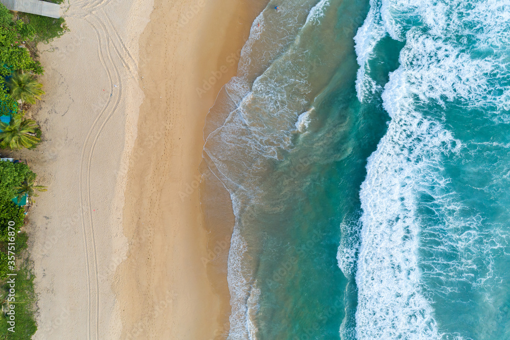 Aerial view sandy beach and crashing waves on sandy shore Beautiful tropical sea in the morning summer season image by Aerial view drone shot, high angle view Top down.