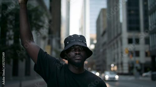 A black man raises his fist in solidarity for social and racial justice.  Peaceful protest for equality and positive change.