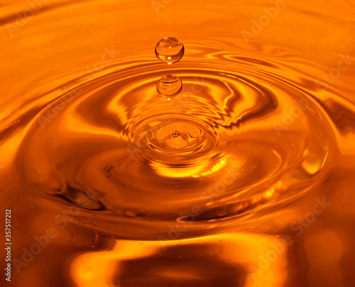 Close up of a drop of water in orange water