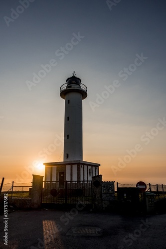 Lighthouse of Lastres at sunset captured in the town of Luces, Spain photo