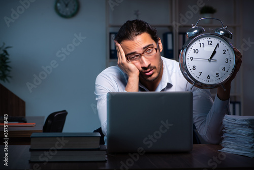 Young male employee working in the office night time