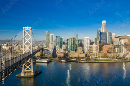 Aerial view of the San Francisco, California, skyline at sunrise. Ample copy space in blue sky. Bay bridge in foreground. © Patrick