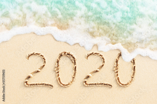 2020 handwritten on the sandy beach