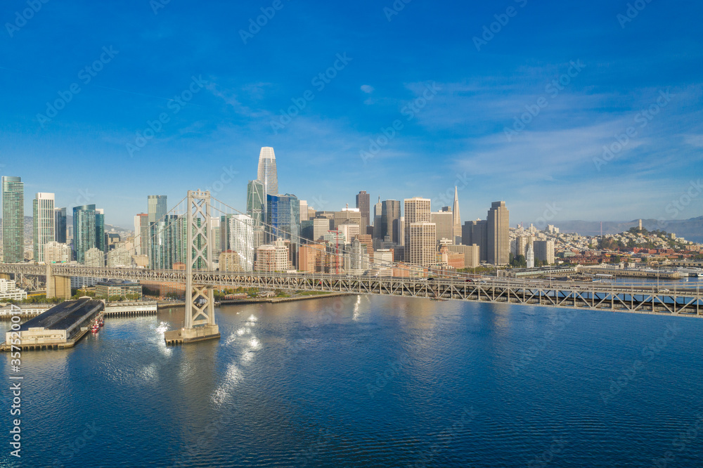Aerial view of the San Francisco, California, skyline at sunrise. Ample copy space in blue sky. Bay bridge in foreground.