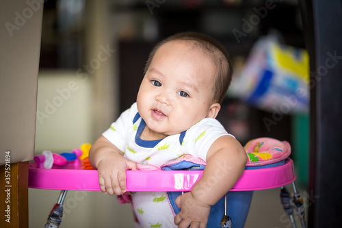 portrait of cute little baby sitting in trolley and smiling to camera