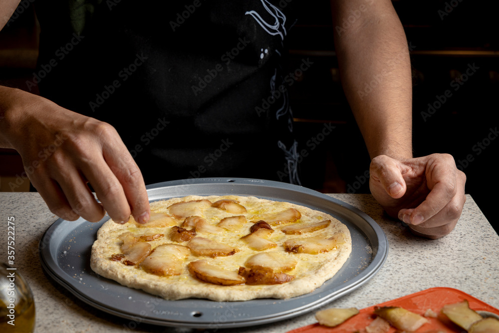 hands making homemade pear and blue cheese pizza