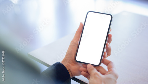 cell phone mockup image blank white screen.woman hand holding texting using mobile on desk at coffee shop.background empty space for advertise.work people contact marketing business,technology