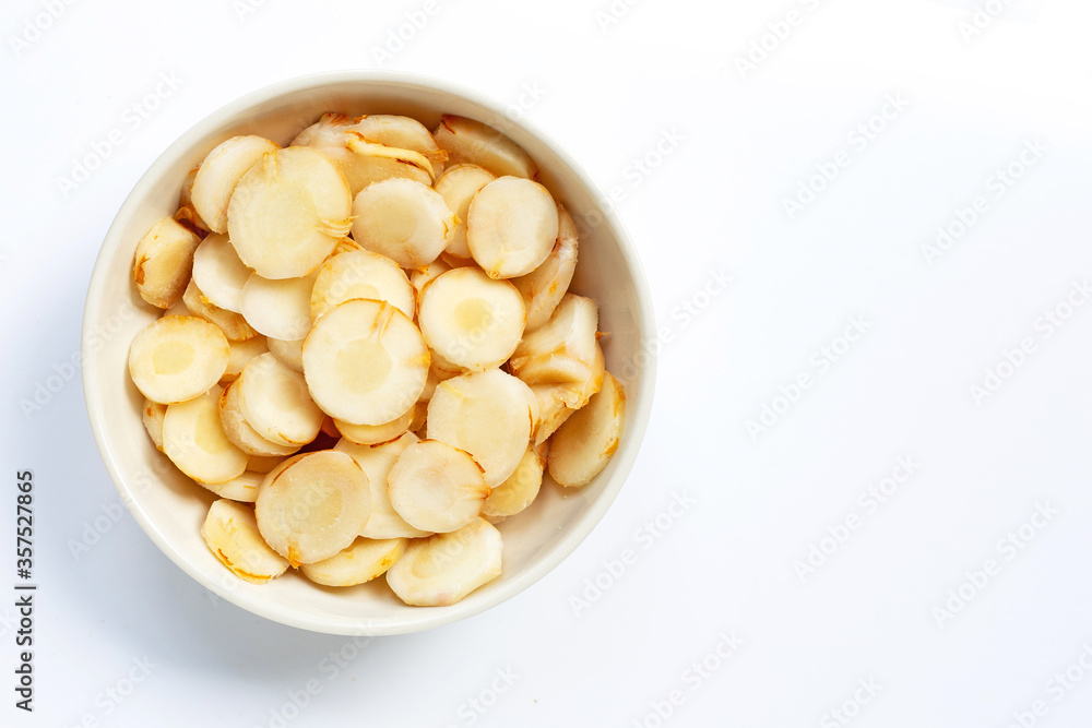 Fresh galangal slices in white bowl isolated on white Fresh galangal slices in white bowl isolated on white