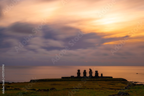 Long Exposure at sunset with Moai statues silhouette and the Pacific Ocean at Ahu Tahai near Hanga Roa village  Rapa Nui  easter Island   Chile.