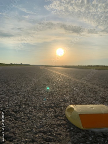 Sunrise on country road. Close up to road reflectors