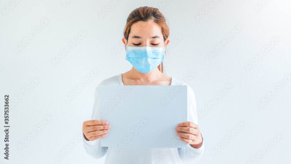 End of Covid-19 pandemic concept. Asian woman wearing medical mask with blank white paper in fight against Pandemic Cure corona virus End of quarantine End of Covid-19 pandemic concept. Asian woman wearing medical mask with blank white paper in fight against Pandemic Cure corona virus End of quarantine
