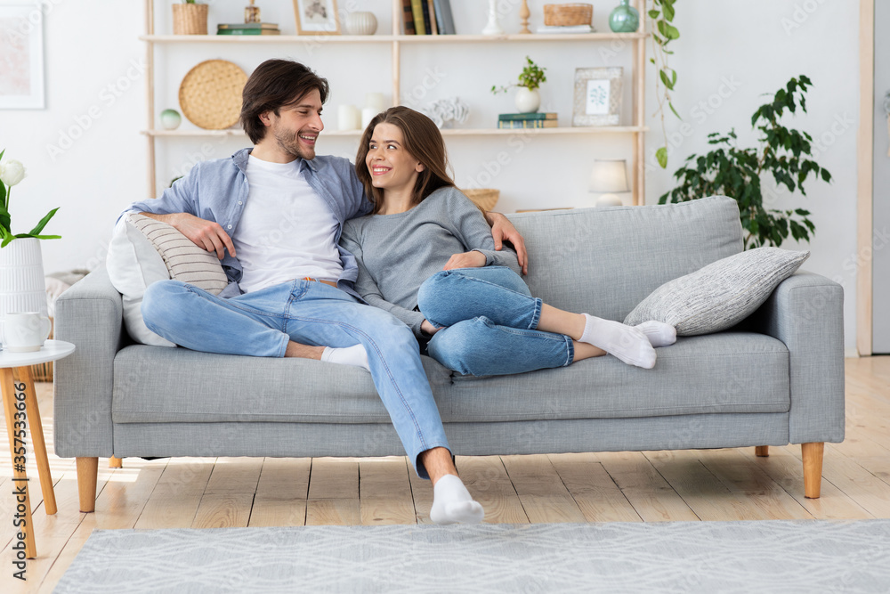 Couple in love hugging on sofa, looking at each other Couple in love hugging on sofa, looking at each other