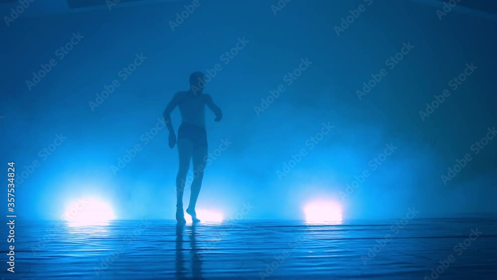 Male dancer performs dance in the scene in the smoke in the spotlight. Modern ballet. Male dancer performs dance in the scene in the smoke in the spotlight. Modern ballet.
