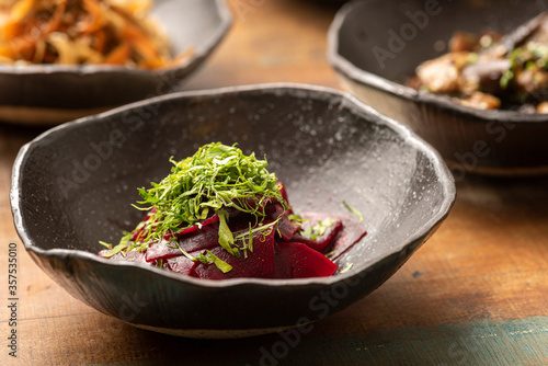 asian fermented kimchi fermented food beet on a black bowl and other ingredients on background