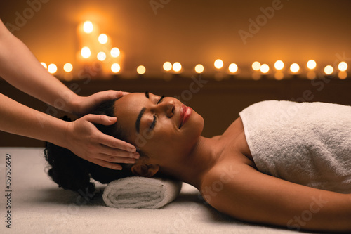 Peaceful african woman attending luxury spa salon
