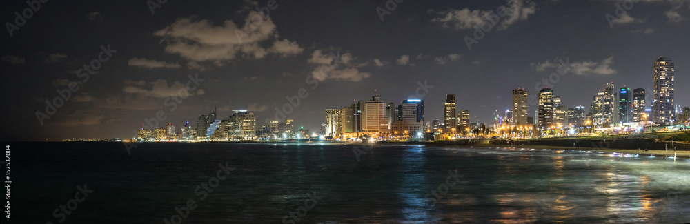 Fototapeta premium Panoramic view at night. Seascape and skyscrapers on background in Tel Aviv, Israel.