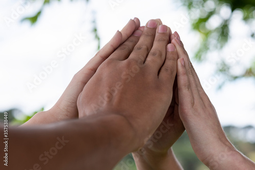 hands together outside forming a symbol of fate teamwork bonding group of people