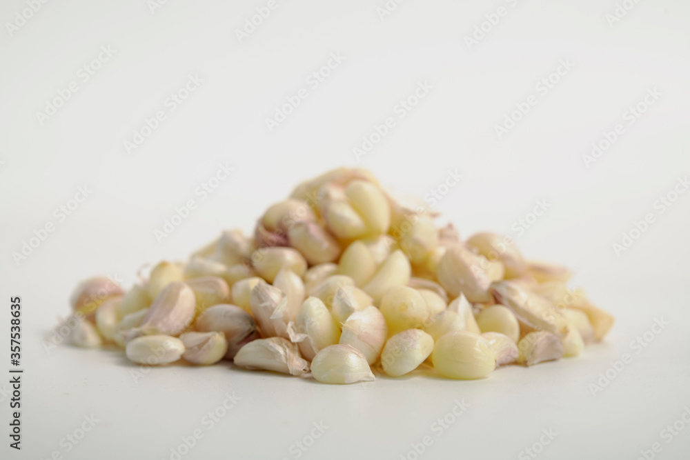 Selected focus on peeled fresh garlic cloves isolated on white background Selected focus on peeled fresh garlic cloves isolated on white background