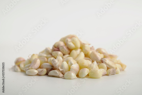 Selected focus on peeled fresh garlic cloves isolated on white background