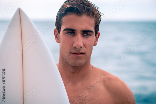 Young man surfer with surfboard portrait