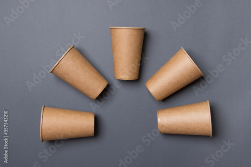 Eco-friendly cardboard cup lie on a gray color paper background. Mock-up. Close-up. The concept of ecology. in form of arch