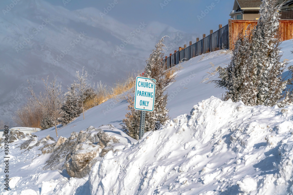 Building and Church Parking Only sign on the snowed in slope of Wasatch Mountain