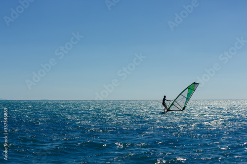 windsurfer panorama silhouette against a sparking blue sea